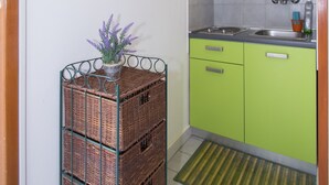 A compact kitchen with green cabinets, a sink, and a small window. - Vacation apartment GABI, Near the beach (Premantura)