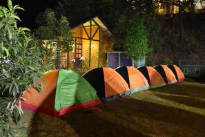 A row of tents in a campsite with a wooden cabin in the background. - I-Camp Resort (Wai)
