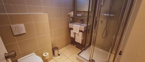 Un baño con inodoro, ducha y lavabo.