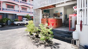 A building with a white facade, red accents, and a visible Coca-Cola refrigerator. - OYO 1172 Goodnight Resort (Phuket)
