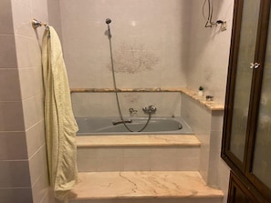 Tina con regadera, secadora de cabello, bidet, toallas