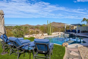 A pool area with lounge chairs, a pergola, and a view of mountains. - Casa Gamble 5 Bedroom Home by RedAwning (Phoenix)