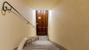 A staircase leading to a wooden door with a sign above it. - Casa Uffizi Tower House Boutique Hotel (Florence)