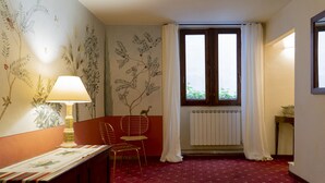 A room with a red carpet, a lamp, a chair, a radiator, and a window with curtains. - Casa Uffizi Tower House Boutique Hotel (Florence)