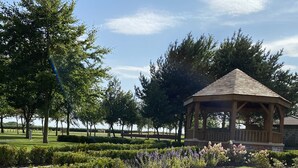 A gazebo in a well-maintained park with manicured lawns and flower beds. - Burntwood Court Hotel (Barnsley)