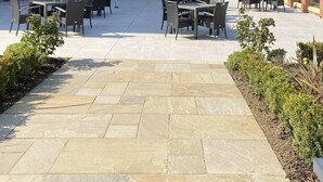 An outdoor patio area with brick buildings, outdoor seating, and a covered section. - Burntwood Court Hotel (Barnsley)