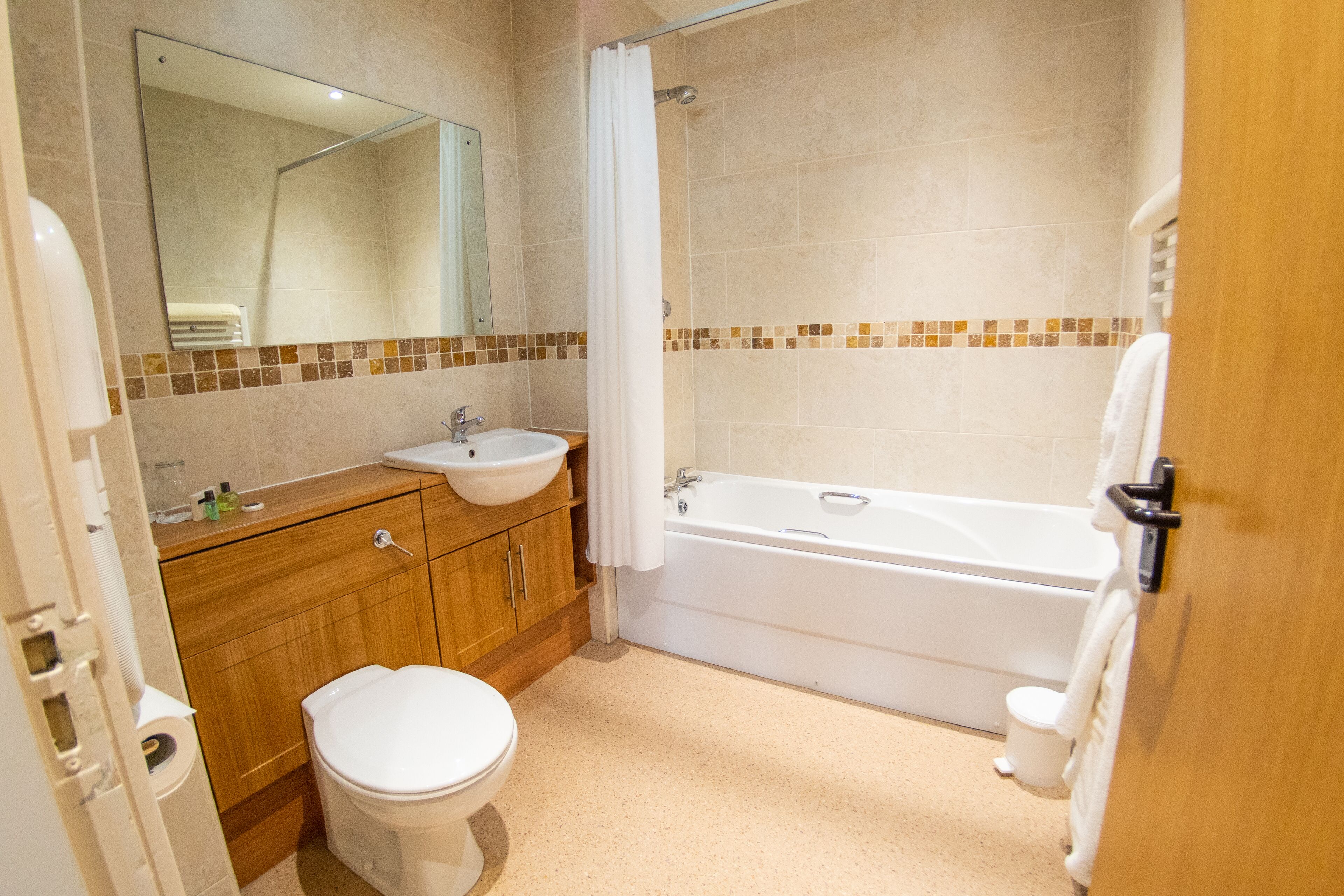 A bathroom with a toilet, sink, and bathtub.