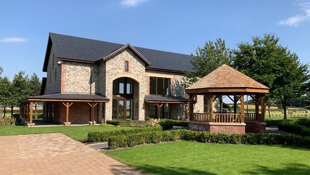 A large stone house with a covered porch and a gazebo. - Burntwood Court Hotel (Barnsley)
