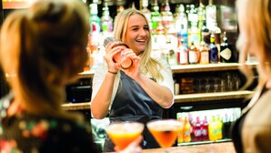 A bartender preparing drinks behind a bar with various bottles and glasses. - Burntwood Court Hotel (Barnsley)