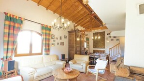 A spacious living room with a high wooden ceiling, a dining area, and a staircase leading upstairs. - Chalet Doire, spacious 6 bedroom chalet (Montgenèvre)