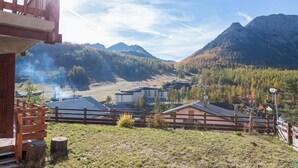 A wooden cabin with a view of mountains and a forested valley. - Chalet Doire, spacious 6 bedroom chalet (Montgenèvre)