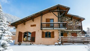 A two-story building with a stone facade, wooden shutters, and a balcony. - Chalet Doire, spacious 6 bedroom chalet (Montgenèvre)