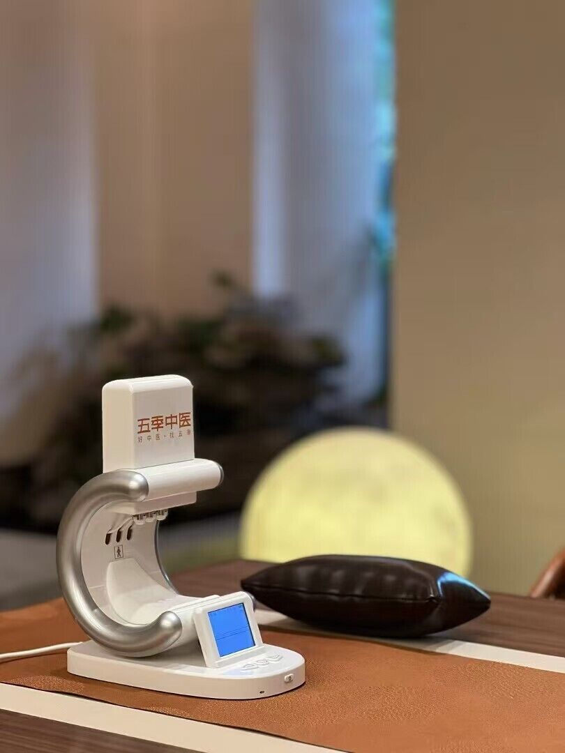 Uma cadeira de massagem com painel de controle e almofada sobre uma mesa.