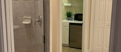 A bathroom with a glass shower door, a toilet, and a sink.