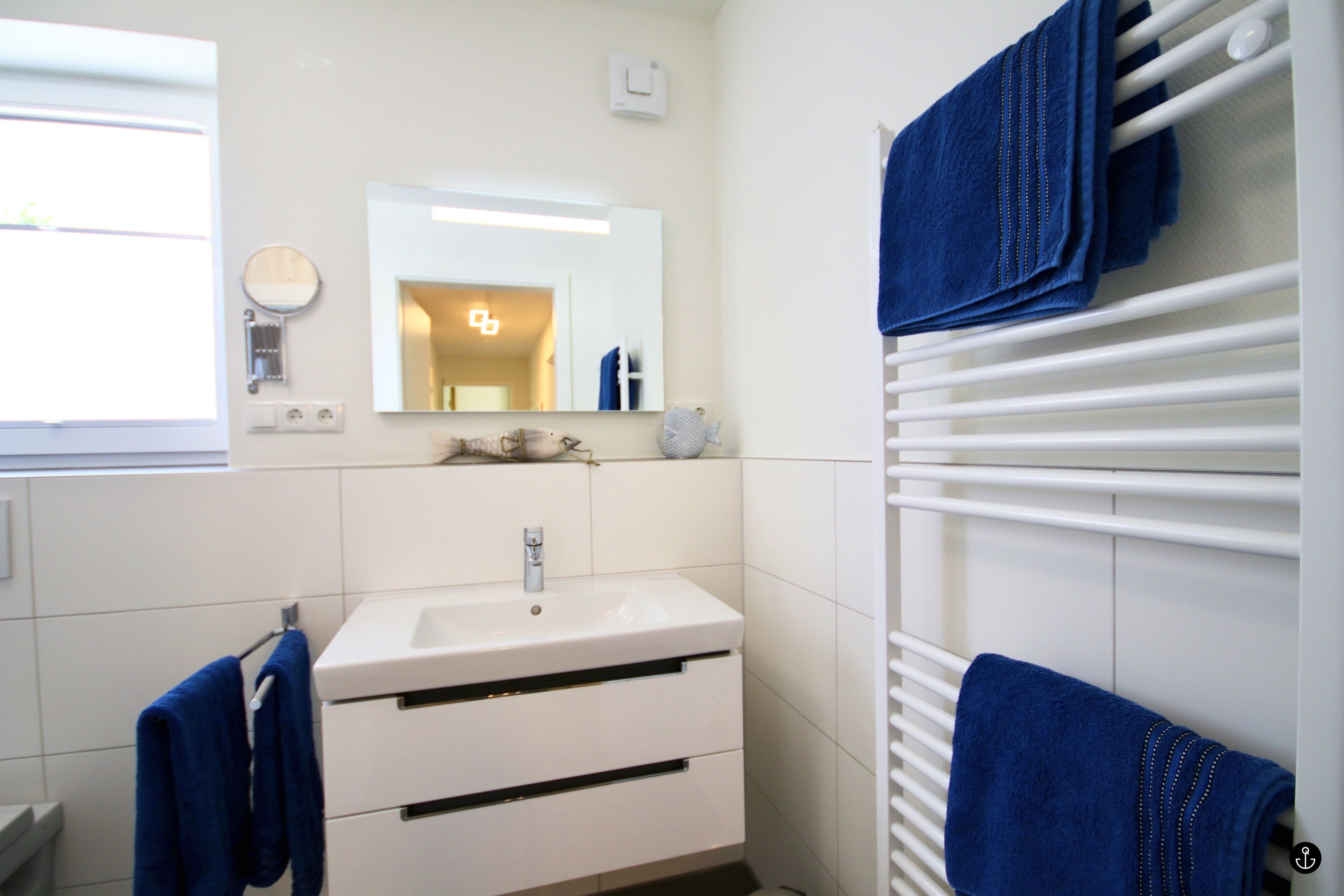 A bathroom with a white sink, mirror, and towel rack.