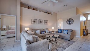A living room with a sectional sofa, a coffee table, and a ceiling fan.