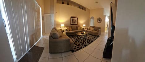 A spacious living room with a sofa set, a coffee table, and a patterned rug.