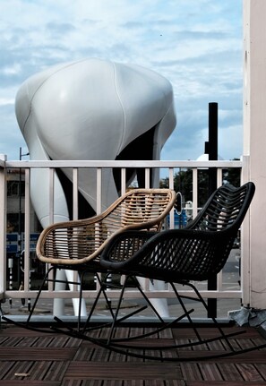 Two wicker chairs on a wooden deck with a modern white structure in the background. - Villa Wanrooy (Doetinchem)