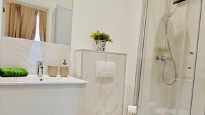 A modern bathroom with a toilet, sink, and shower. - Comfortable 1 bedroom - Fully equipped kitchen - Brussels center (Bruxelles)