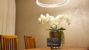 Taula de menjador amb un ram d'orquídees blanques, un senyal amb la paraula 
