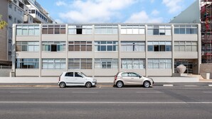 A modern building with a flat facade, multiple windows, and a visible entrance. - Mouille Point Studio with Breathtaking Views (Cape Town)