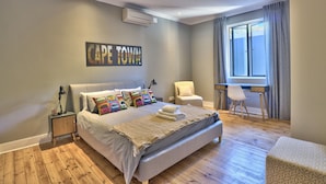 Une chambre à coucher avec un lit, une chaise, un bureau et une fenêtre.