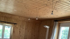 Et træhusværelse med to senge, et vindue og en loftlampe.