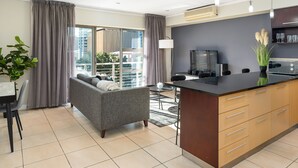 A modern apartment with a living area, kitchen, and balcony.