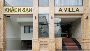 Eine Hotelansicht mit zwei Eingängen, auf denen "KHÂCH SAN" und "A VILLA" stehen.