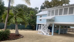 A building with a covered outdoor area, a white staircase, and a gravel ground. - ~Free Bike Rides - 3 miles from John Pennekamp - Your Happy Place~ (Key Largo)