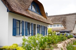 A traditional house with a thatched roof and blue shutters. - Reethaus Kleiner Seestern ***** Sauna, close to the beach, plenty of space, and quiet (Kalkhorst)