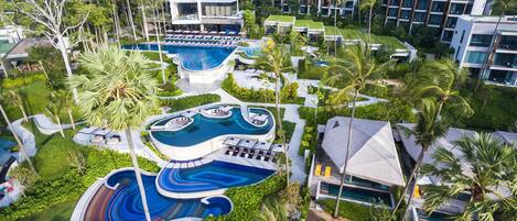 A resort with multiple swimming pools, a variety of lounge areas, and modern buildings.