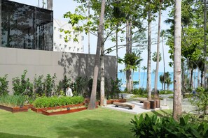 A modern outdoor area with a seating area, planters, and a view of the sea.