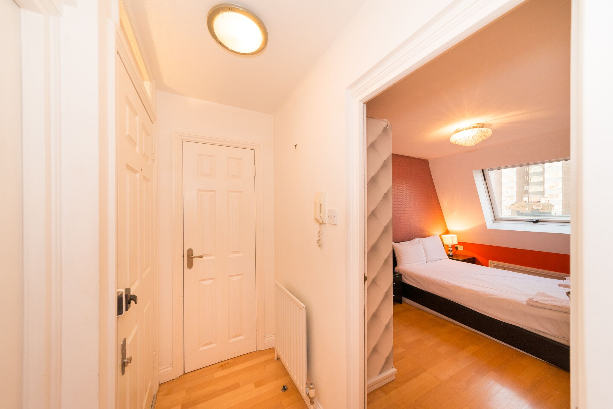 Ein Schlafzimmer mit Bett, Fenster und Tür.