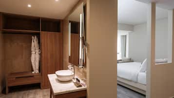 Un bagno moderno con uno specchio grande, un mobile bagno in legno e una vasca da bagno.
