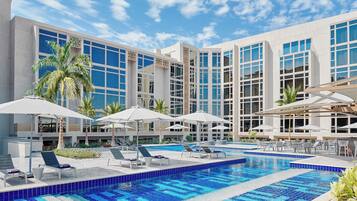 Una piscina al aire libre, tumbonas