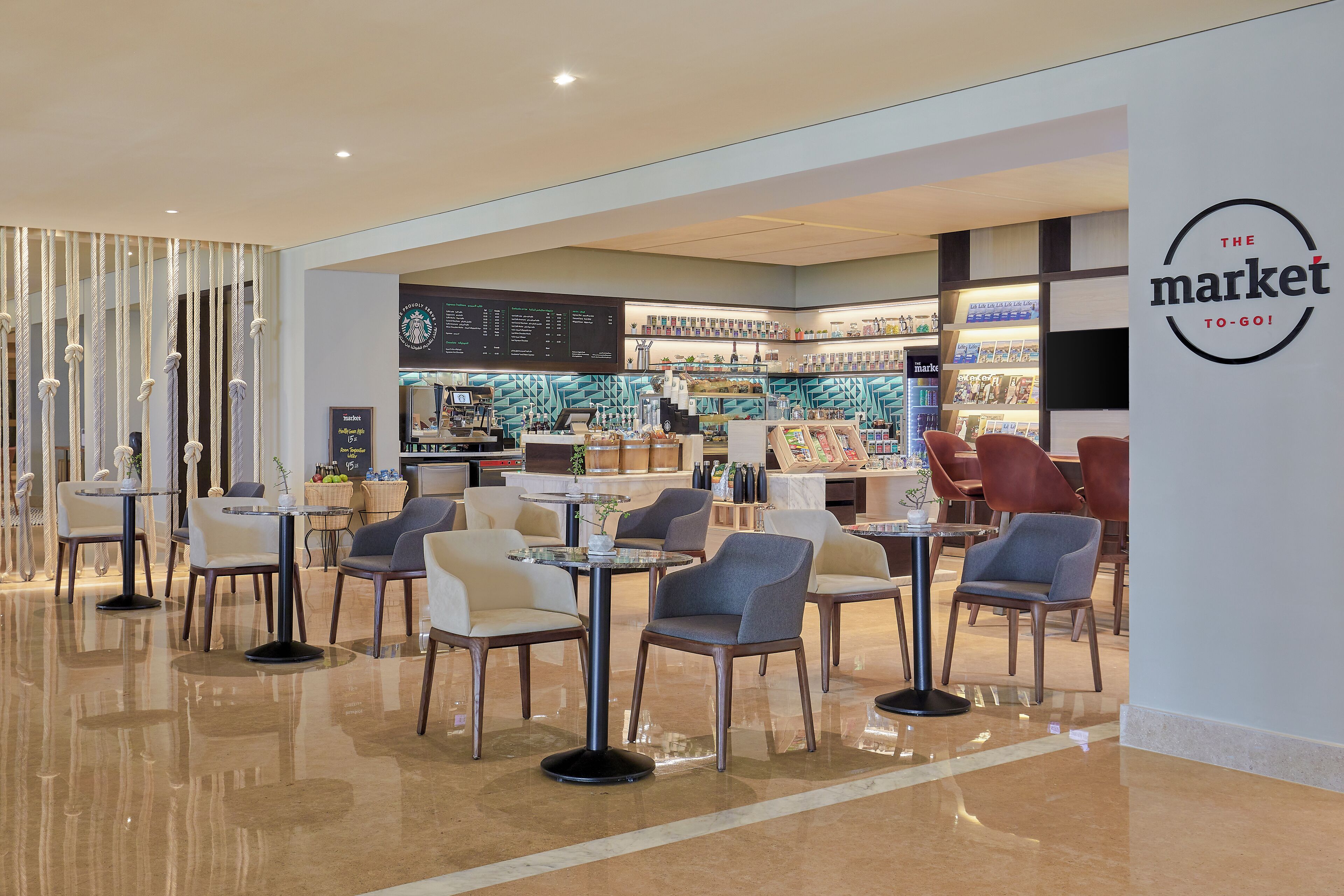 A modern cafe with a clean, minimalist design, featuring a variety of seating options and a visible menu board.