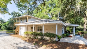A two-story house with a covered porch, a front entrance, and a driveway leading to the front door.