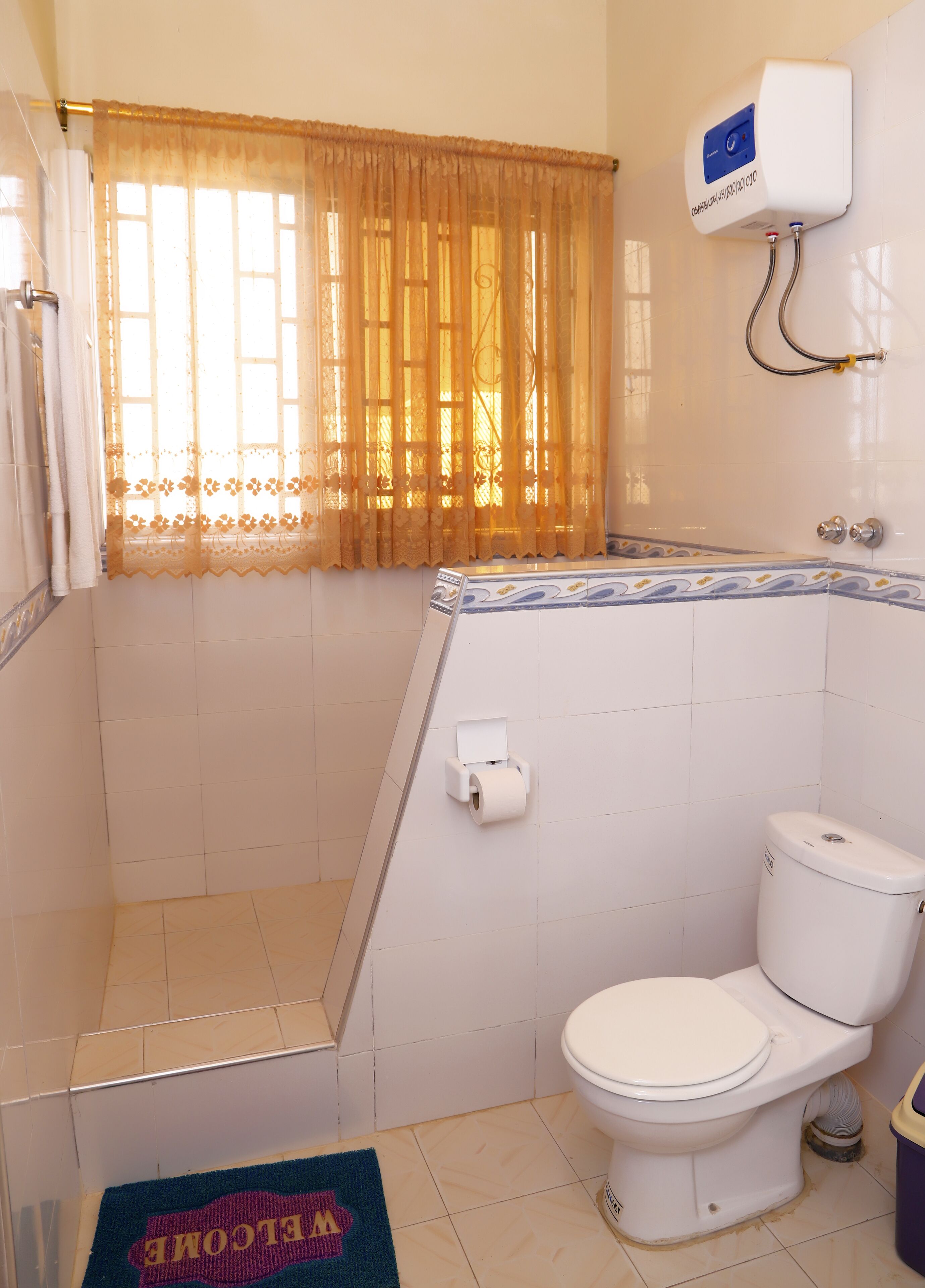A bathroom with a toilet, a shower, and a toilet paper holder.