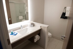 Uma casa de banho moderna com uma pia dupla, um espelho, um porta-toalhas e uma sanita.
