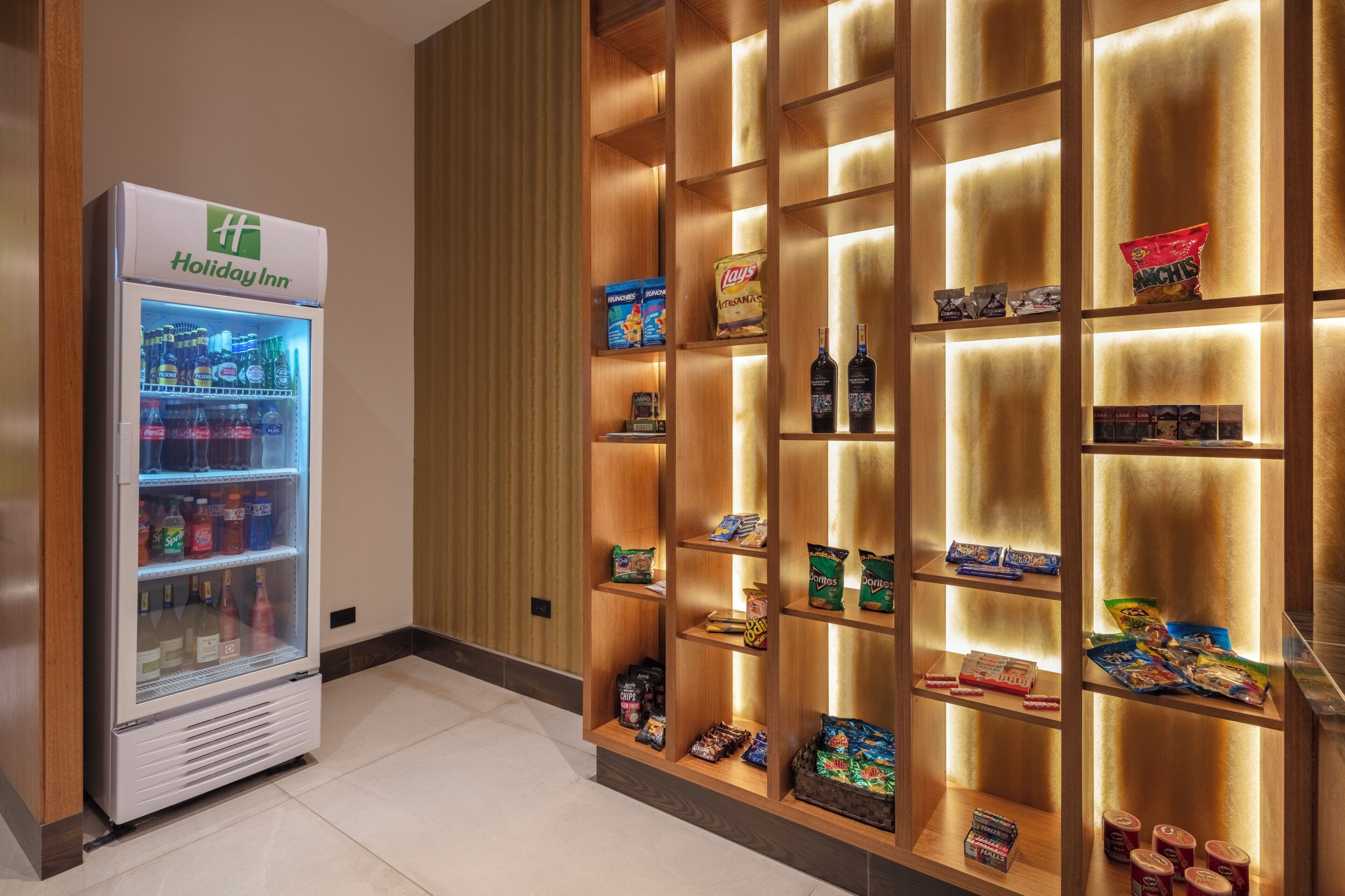 Habitación de Holiday Inn con un minibár abastecido con aperitivos, bebidas y bombones.