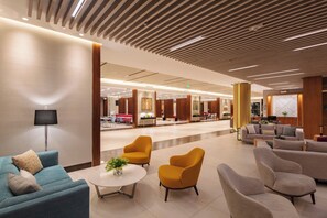 A modern lobby with a seating area, a dining section, and a reception desk. - Holiday Inn Quito Airport by IHG (Tababela)