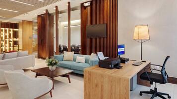Un moderno vestíbulo de hotel con mostrador de recepción, zona de estar y una gran pantalla.