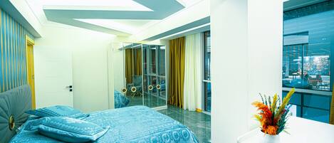 A modern bedroom with a bed, a bedside table, a mirror, and a window with curtains.