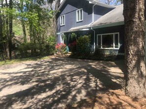 Set amidst a serene wooded area, this two-story house offers a peaceful retreat surrounded by a beautifully maintained garden.