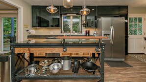 A modern kitchen with a central island, stainless steel appliances, and pendant lighting. - Family Launch Pad (Asheville)