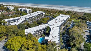 A resort with multiple buildings, a parking area, and a beach view. - Direct Ocean Front First Floor 1BR/1Bath Condo (Hilton Head Island)