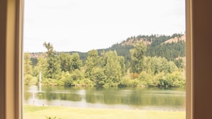 Una ventana con vistas a un lago rodeado de vegetación y un cartel que dice "The Best Place to Be Is Together".