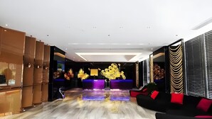 A modern hotel lobby with a marble floor, a reception desk, and a seating area with black and red sofas. - Greentree Alliance Hotel Guiyang Huaguo Community Central Business Zone (Guiyang)