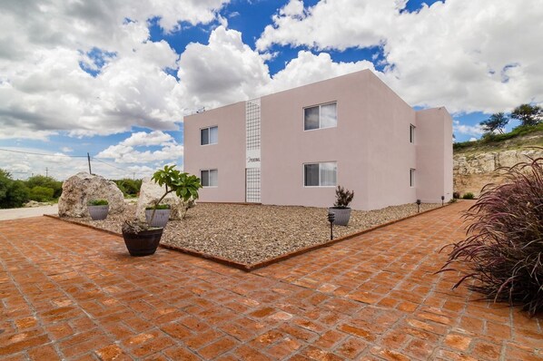 A modern two-story building with a flat roof and a light pink facade. - Pedernal Hotel (San Miguel de Allende)